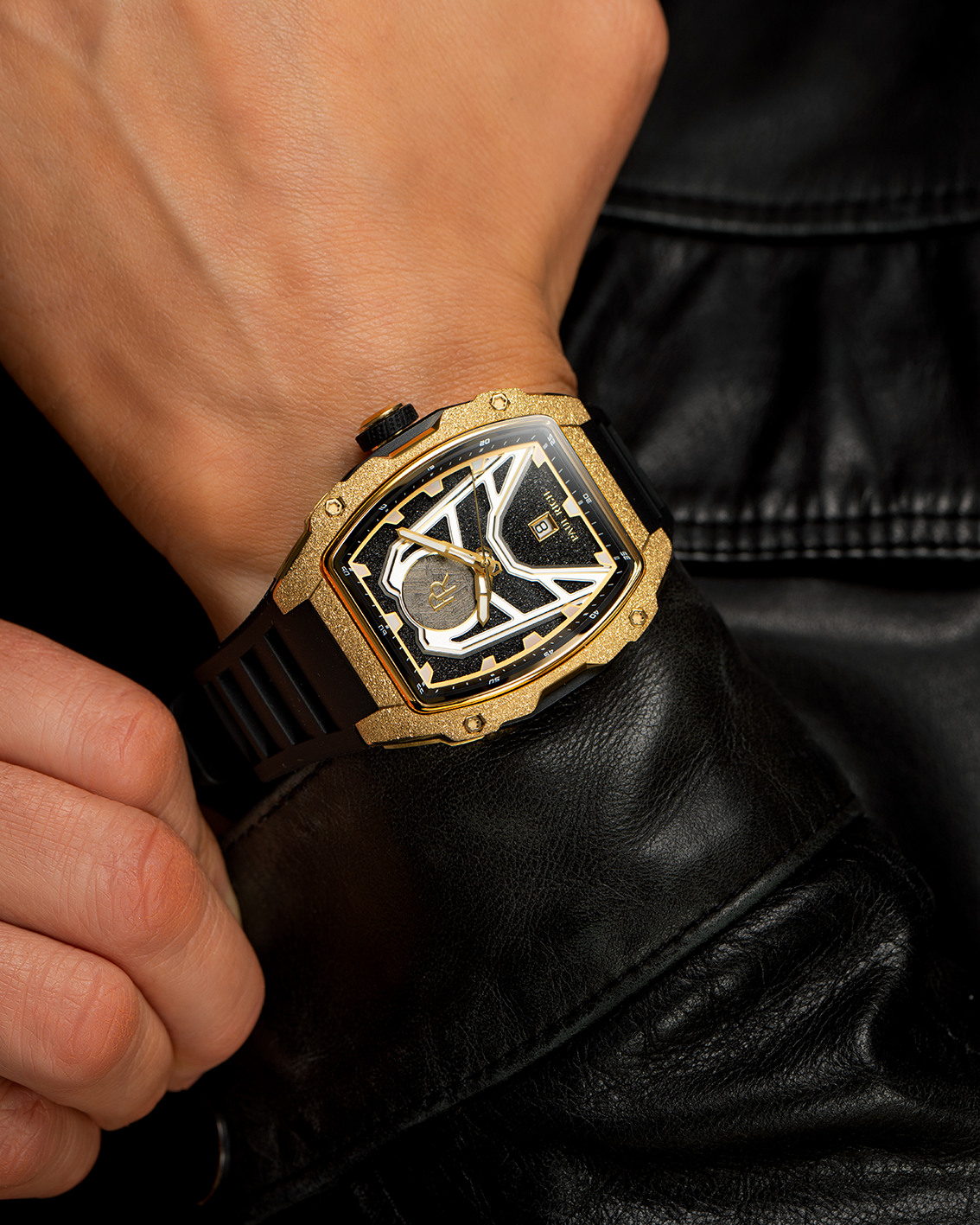 Paul Rich Astro Meteora with frosted gold bezel, meteorite inlay, and black rubber strap, worn with a black leather jacket.