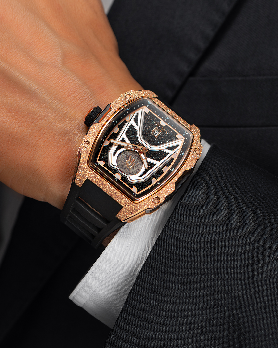Paul Rich Astro Meteora with frosted rose gold bezel, meteorite inlay, black dial accents, worn with a black suit and white cuff.