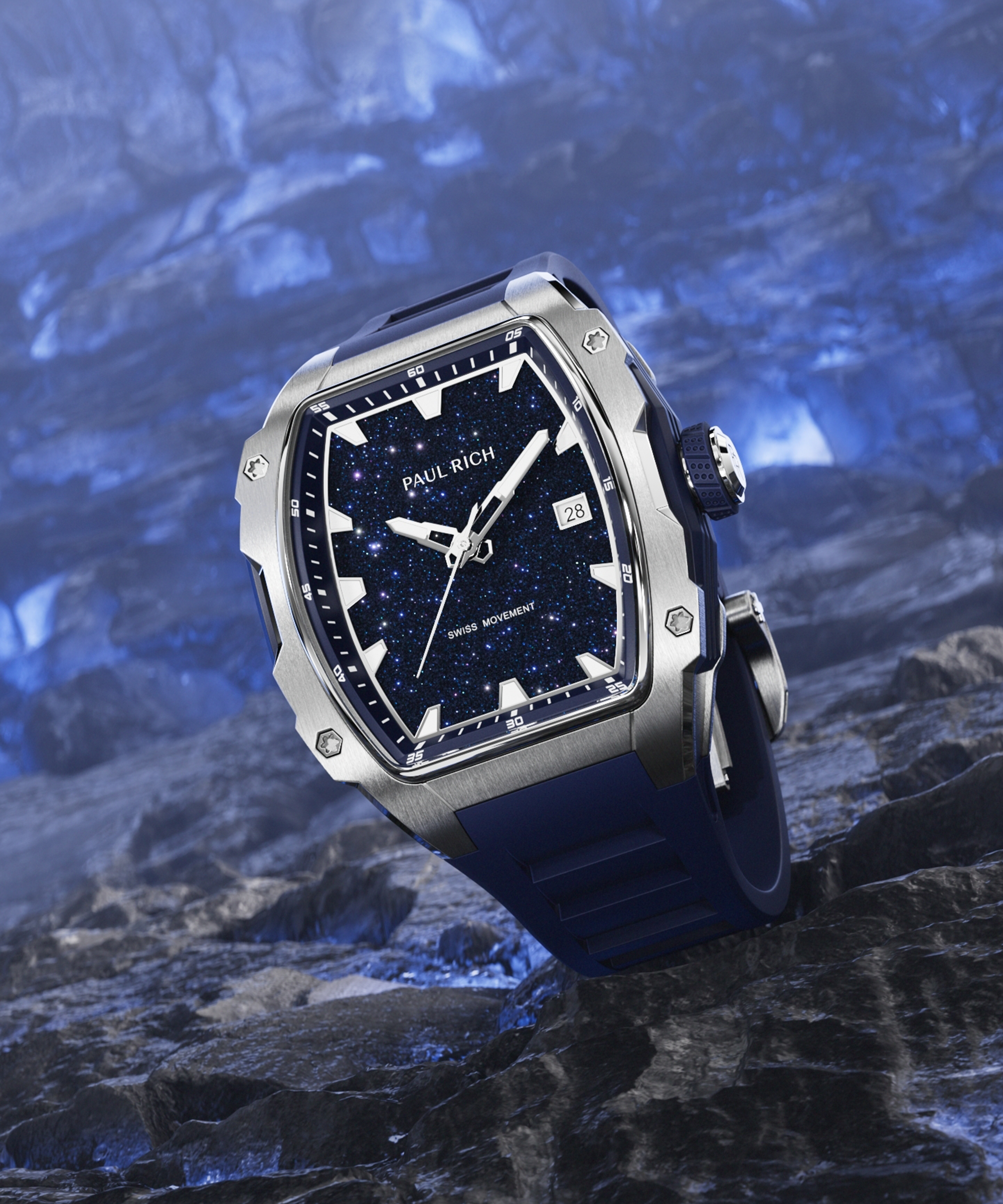 Paul Rich silver-tonneau watch with blue aventurine dial, silver hands, and blue strap displayed on textured dark blue rock surface.