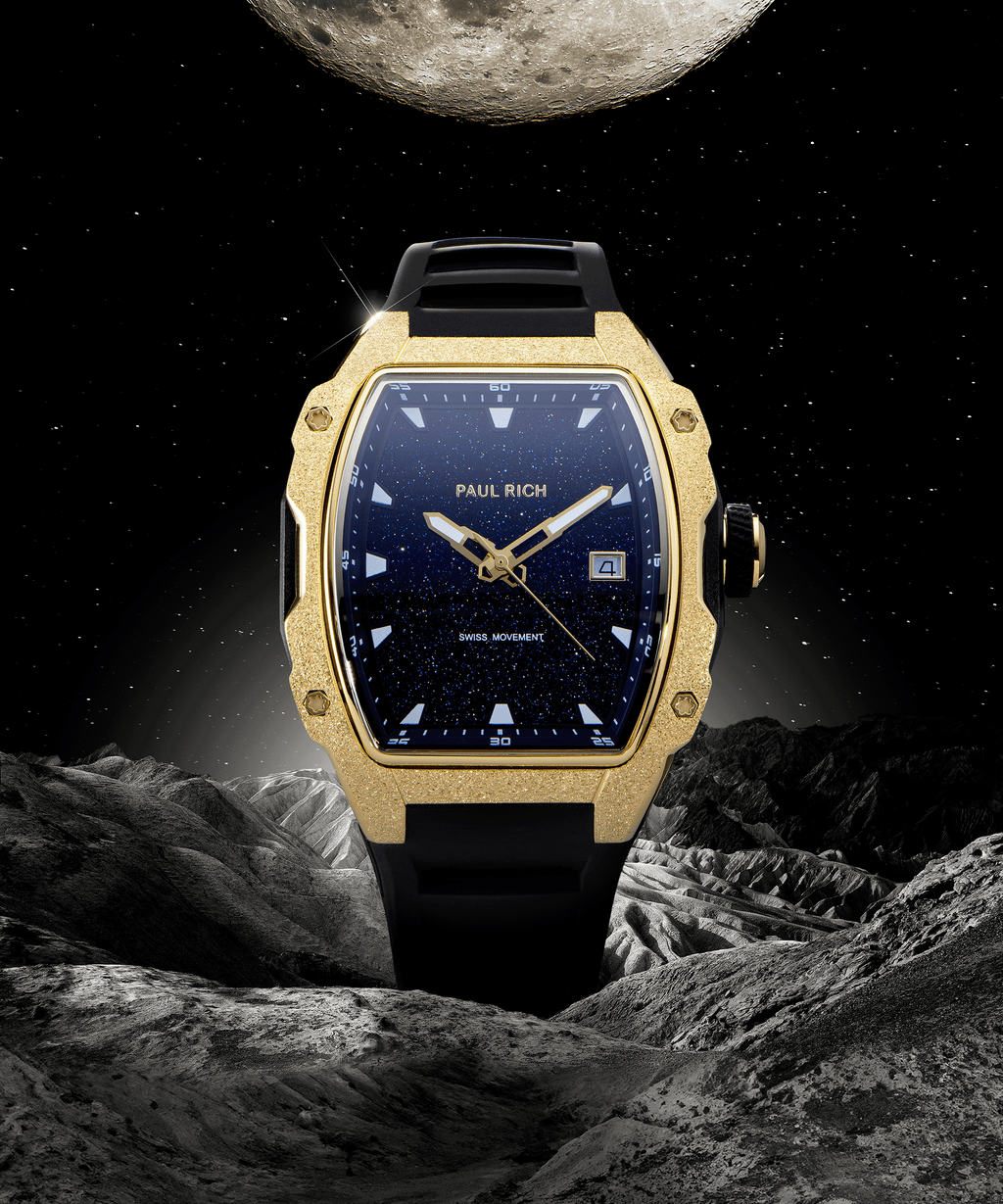 Paul Rich tonneau-shaped watch with blue aventurine dial and gold frosted bezel displayed against moonlit space and rocky lunar terrain.