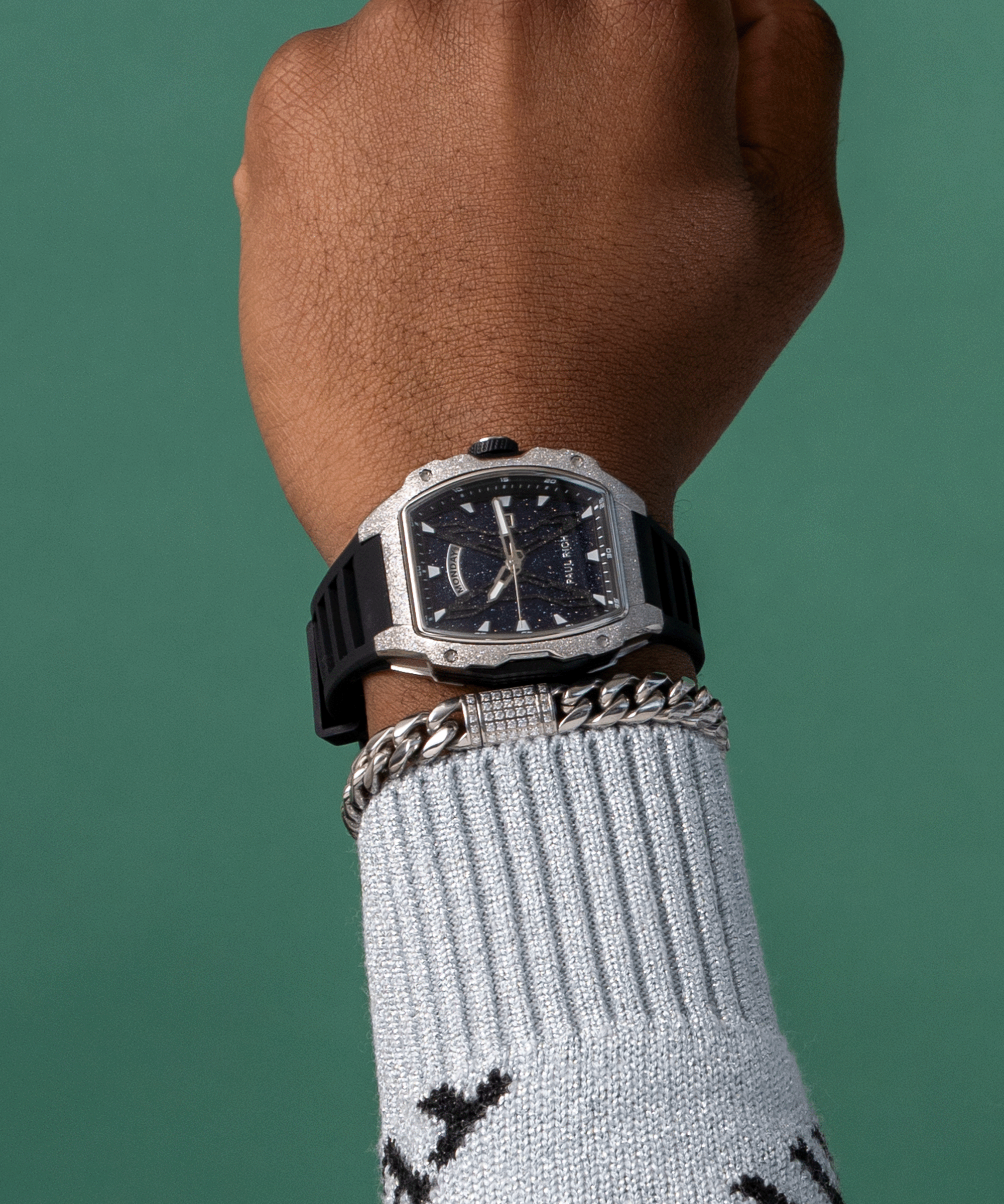 Paul Rich watch with blue aventurine dial and silver frosted bezel worn on wrist, paired with silver bracelet and light blue sweater.