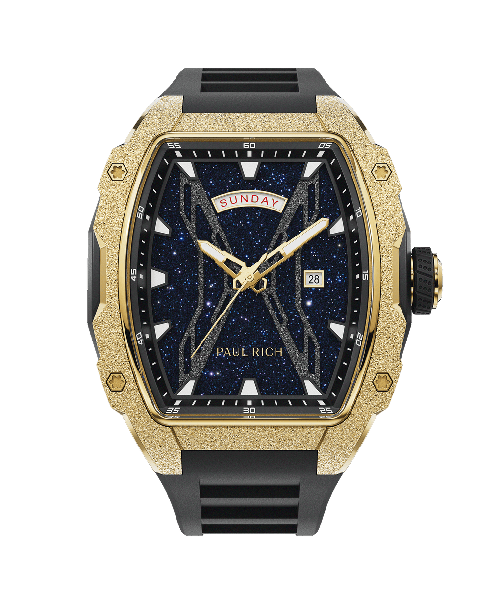Paul Rich watch with frosted gold tonneau case, blue aventurine dial, gold hands, day-date display, and black rubber strap, shown front-facing.