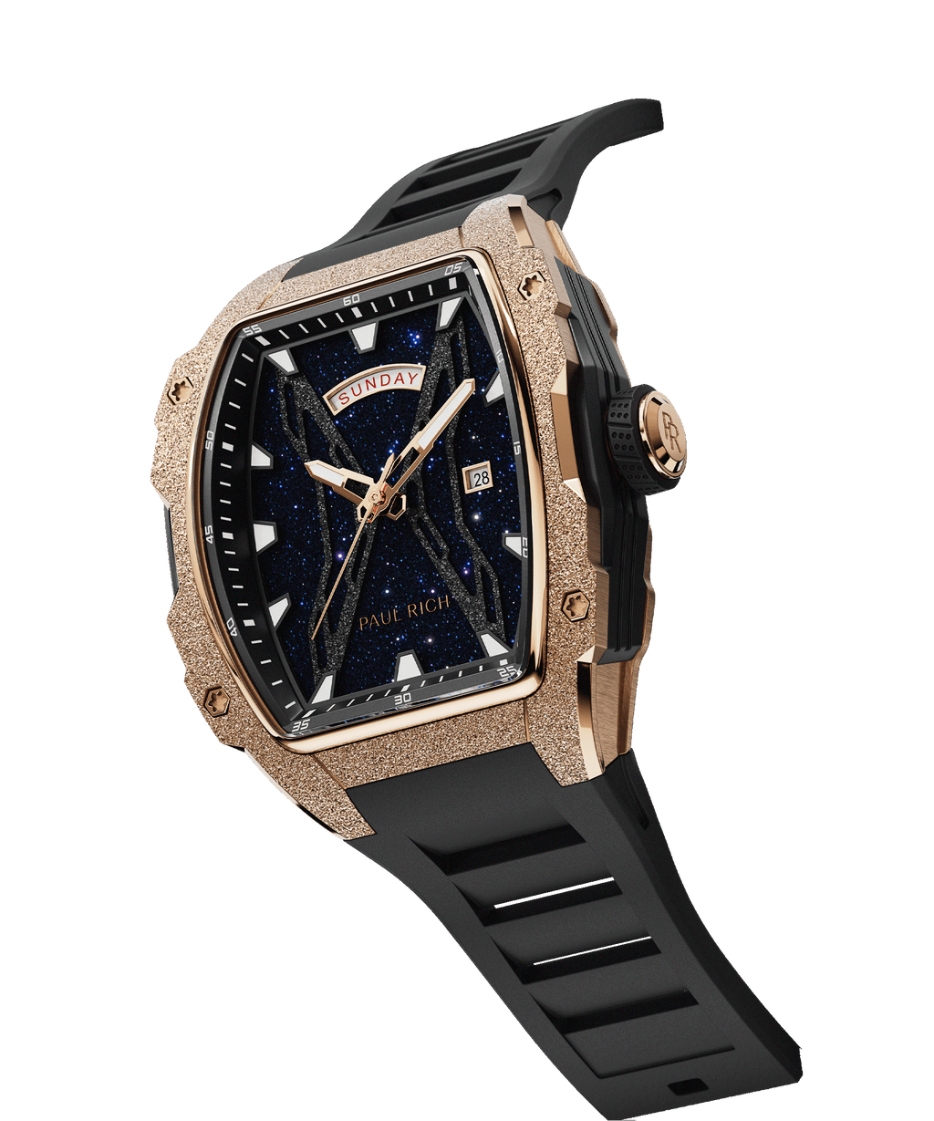 Angled view of Paul Rich watch with frosted rose gold tonneau case, blue aventurine dial, day-date display, and black rubber strap.