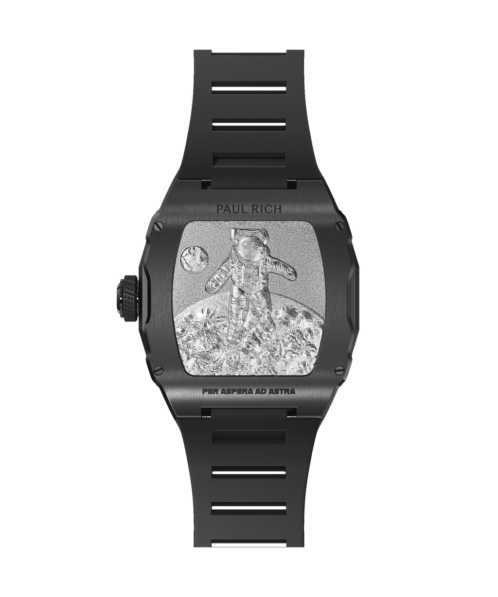 Caseback of tonneau-shaped Paul Rich watch with black casing, engraved astronaut on lunar surface, and “PER ASPERA AD ASTRA” text.