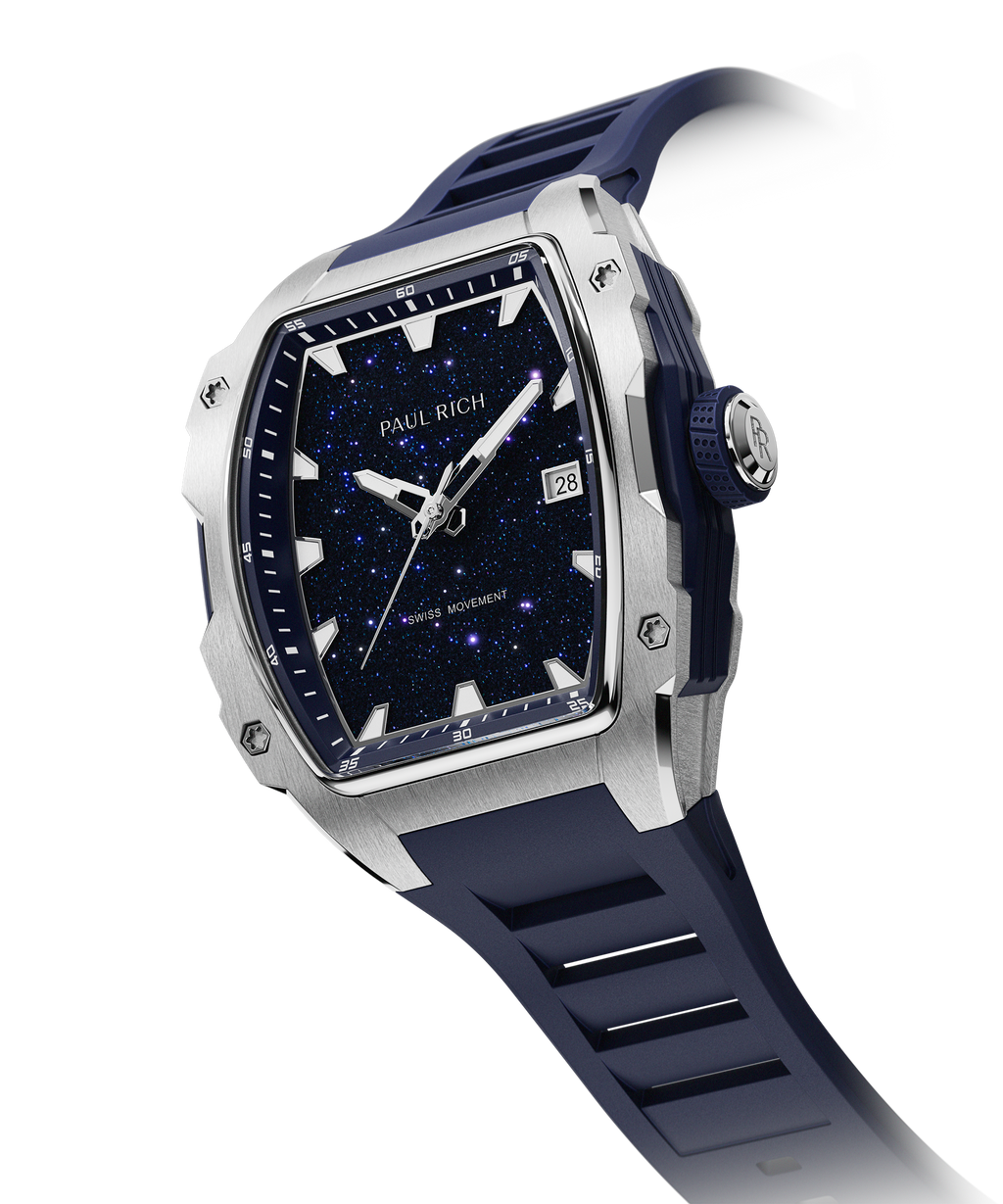 Angled view of a Paul Rich silver-tonneau watch with blue aventurine dial, silver hands, date window, and blue textured rubber strap.