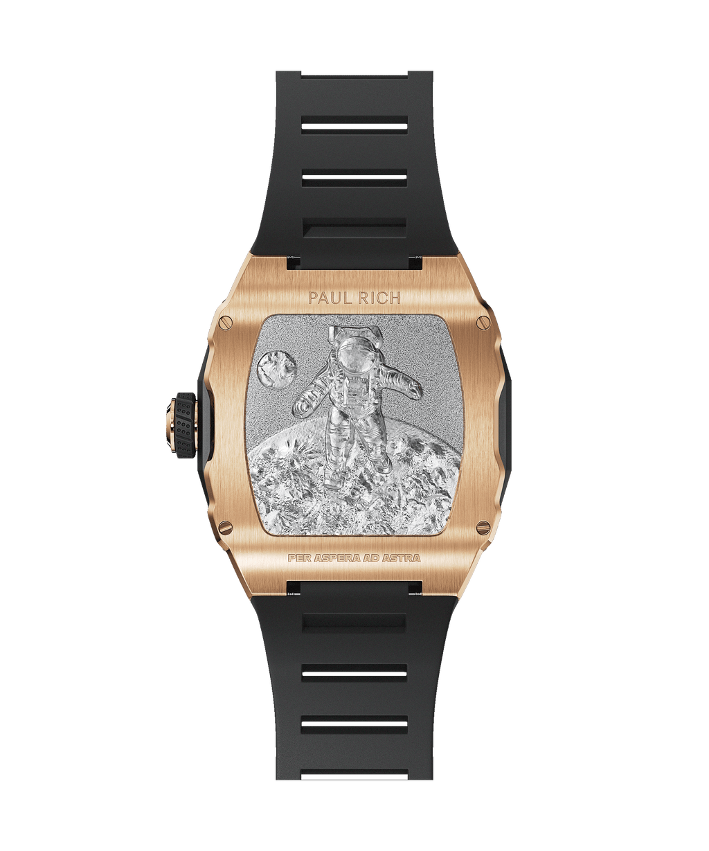Caseback of Paul Rich watch with rose gold casing, astronaut engraving on lunar surface, black rubber strap, and “PER ASPERA AD ASTRA” text.