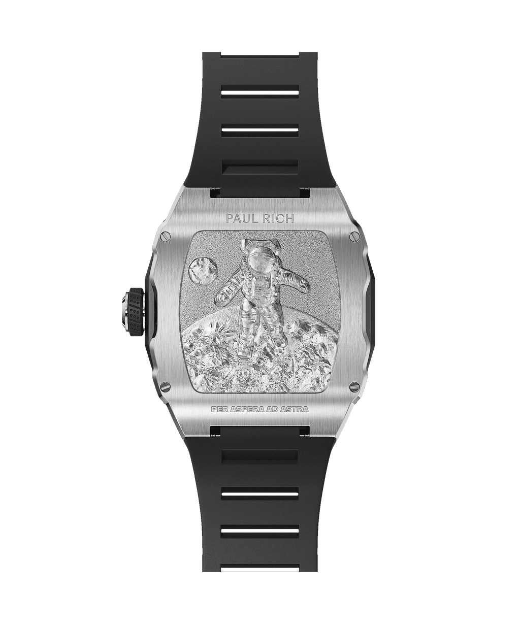 Caseback of Paul Rich watch with silver engraving of astronaut on lunar surface, black rubber strap, and “PER ASPERA AD ASTRA” text.