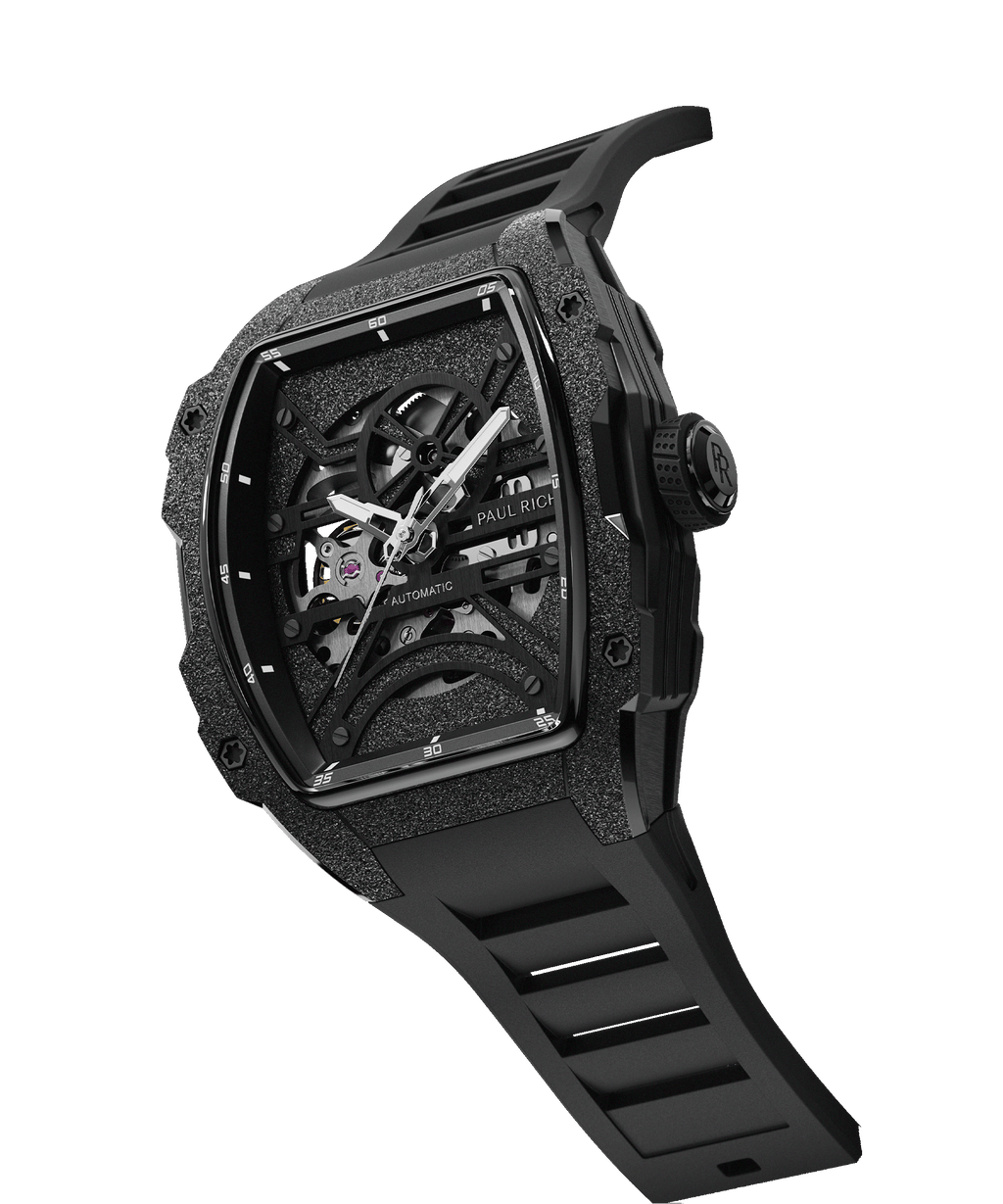 Angled view of Paul Rich watch with frosted black tonneau case, silver skeleton dial, white hands, and black rubber strap, on transparent background.