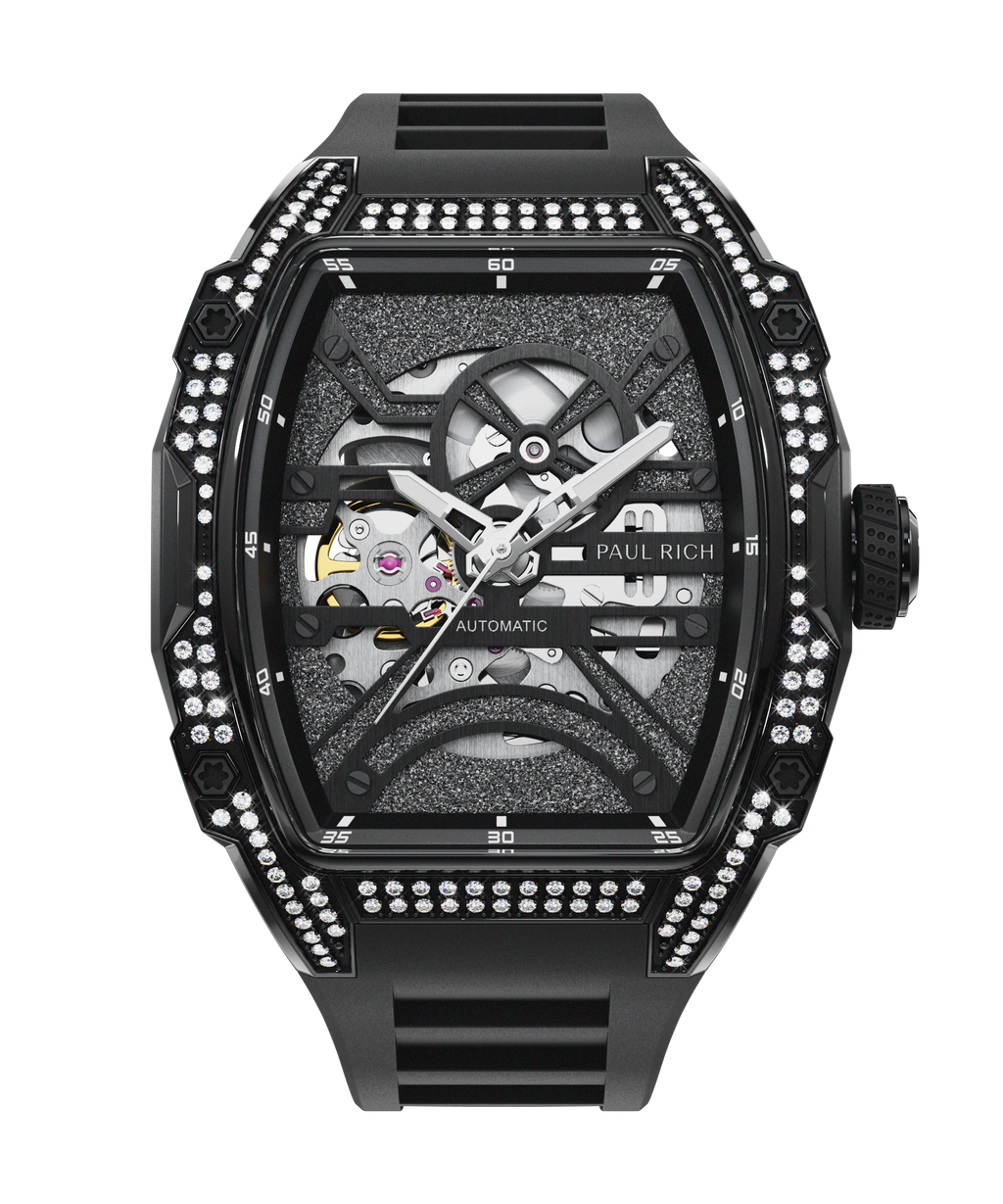 Front view of black open dial watch with silver automatic movement, black strap, and diamond-set case on white background.