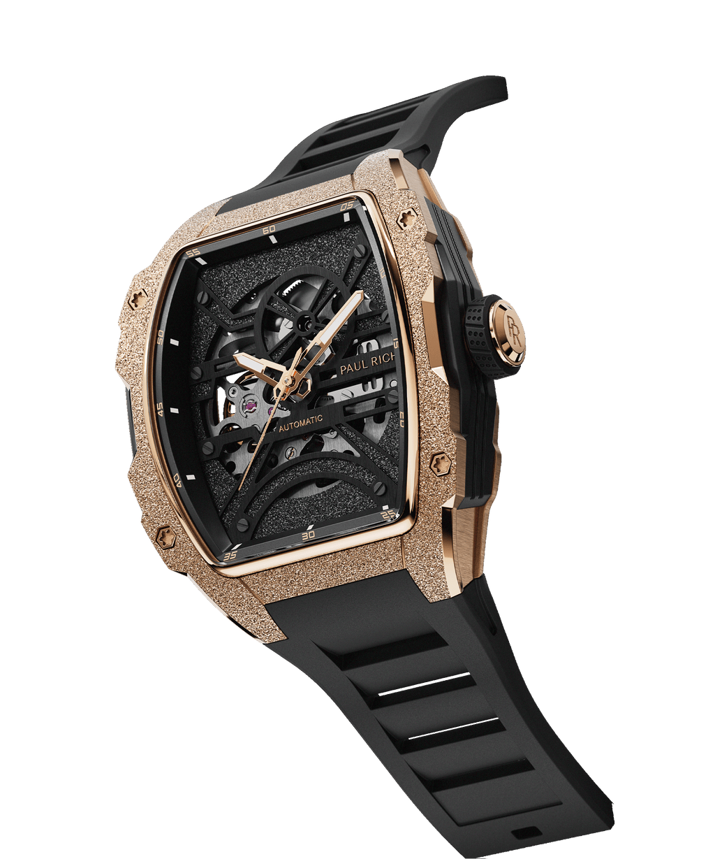 Angled view of Paul Rich watch with frosted rose gold tonneau case, skeleton dial, and black rubber strap, shown on transparent background.