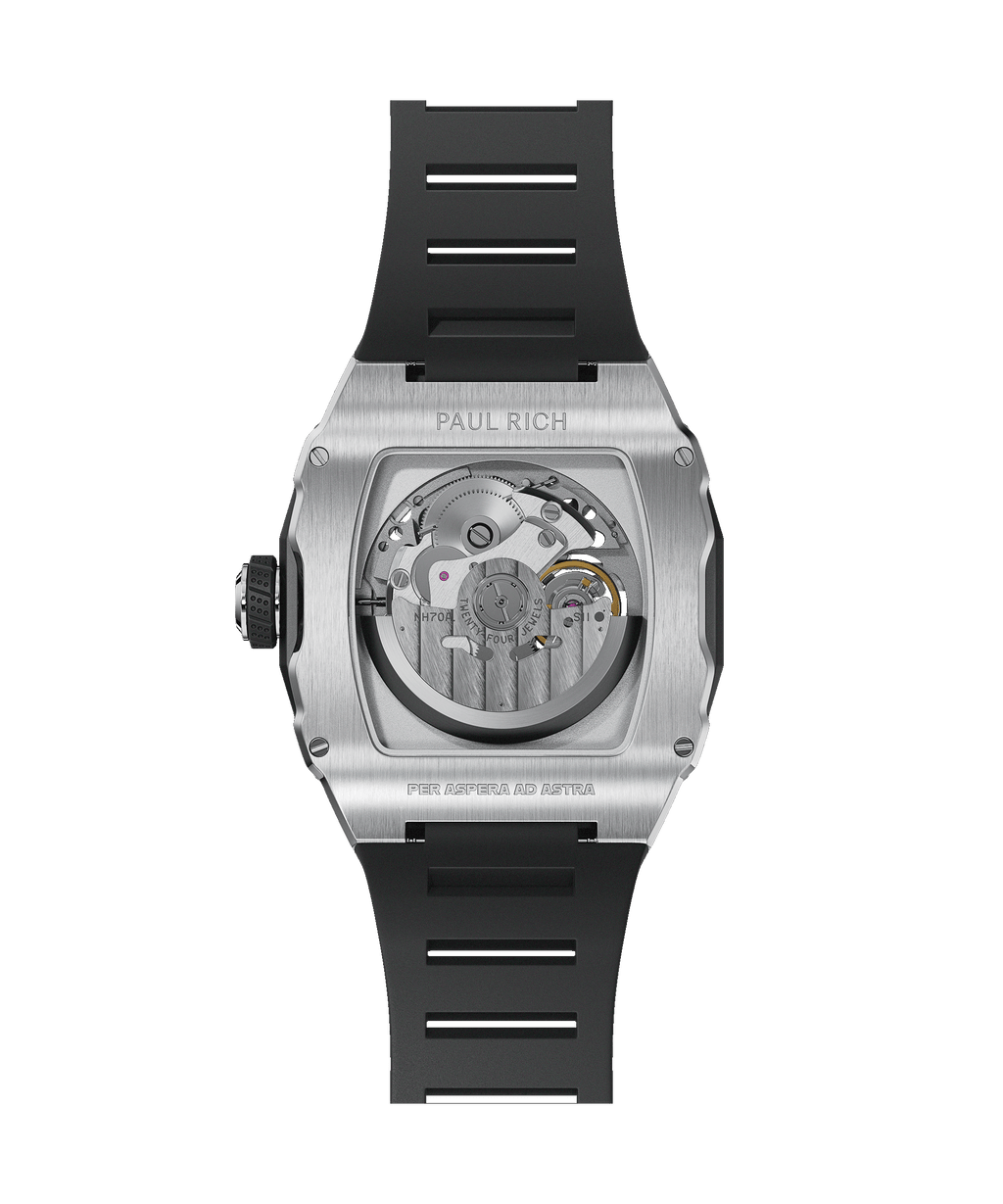 Back view of a tonneau-shaped wristwatch with a visible automatic movement, brushed steel case, black rubber strap, and “Per Aspera Ad Astra” engraved.