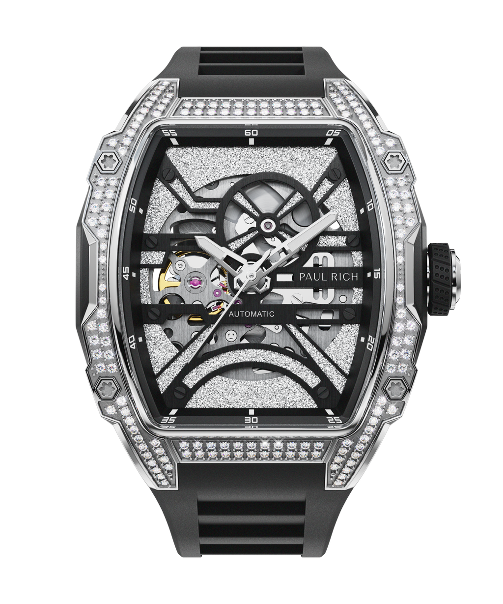 Black tonneau-shaped wristwatch with a skeleton dial, crystal-set bezel, textured metallic surfaces, and a black rubber strap shown on a transparent background.