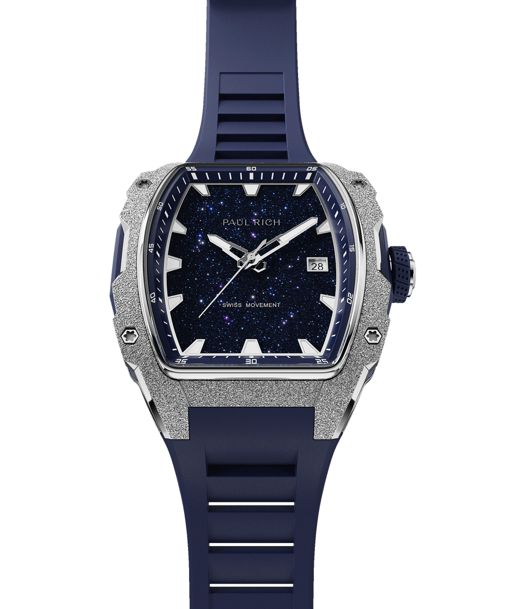 Paul Rich watch with frosted silver bezel, blue aventurine dial, date window, and blue rubber strap, in tonneau case, shown vertically.