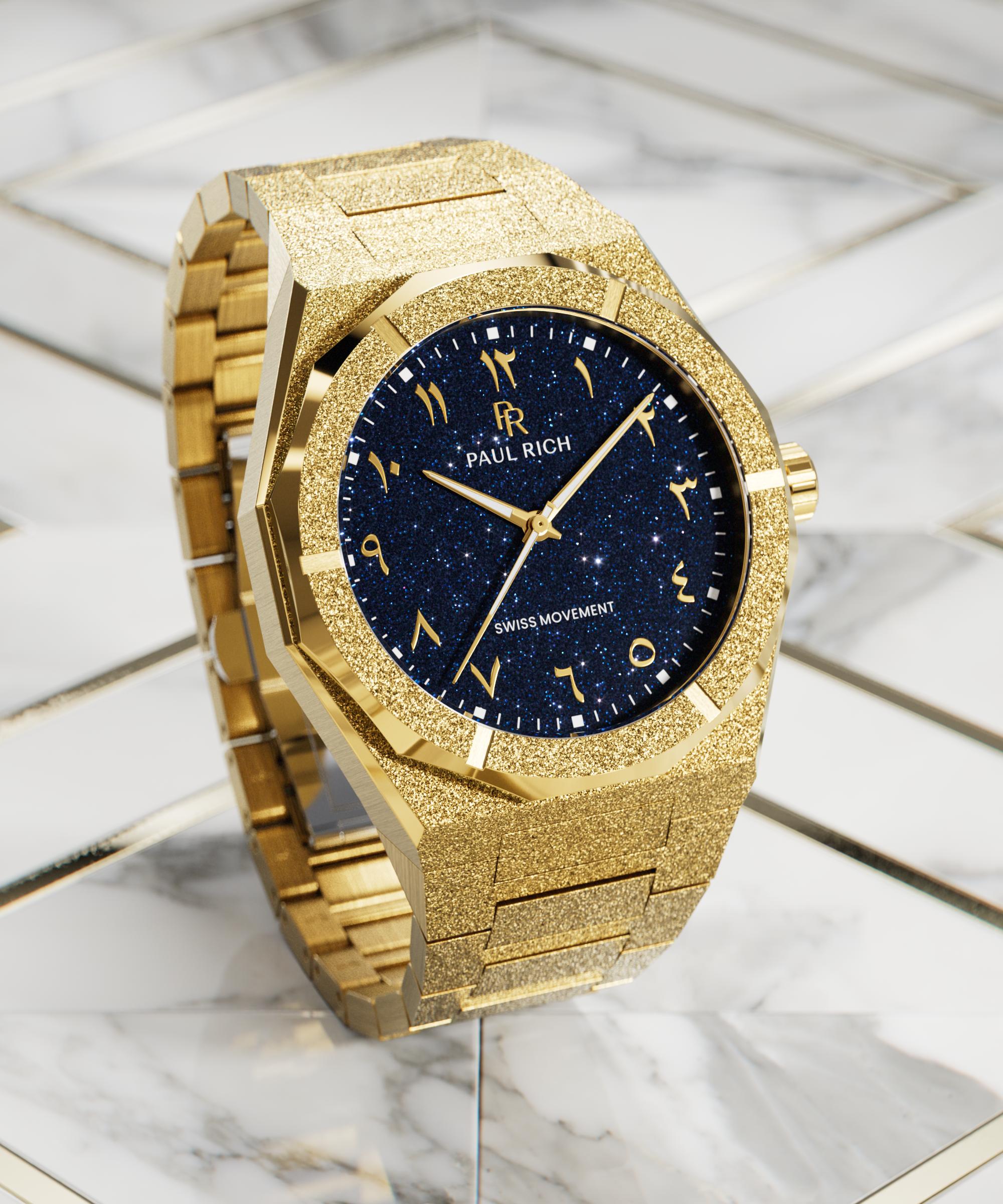 Frosted gold watch with blue aventurine dial and Arabic numerals, displayed on a white marble and gold geometric surface.