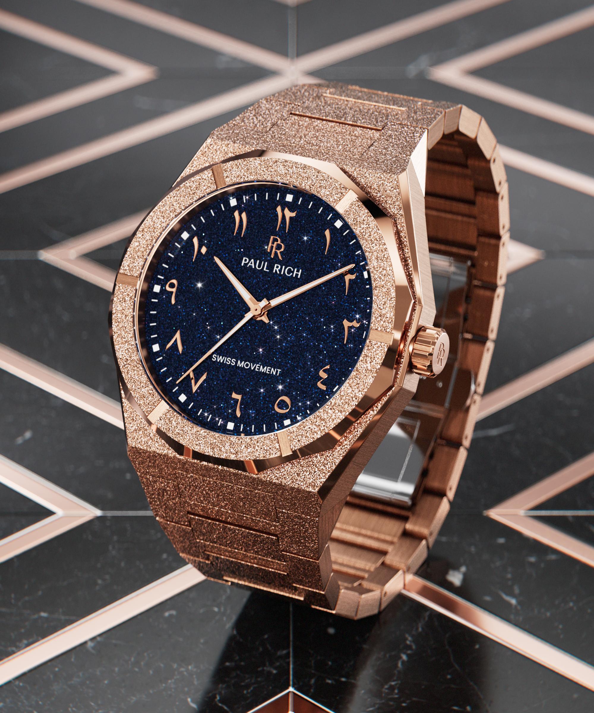 Frosted rose gold watch with blue aventurine dial and Arabic numerals, displayed on a glossy black and rose gold geometric surface.