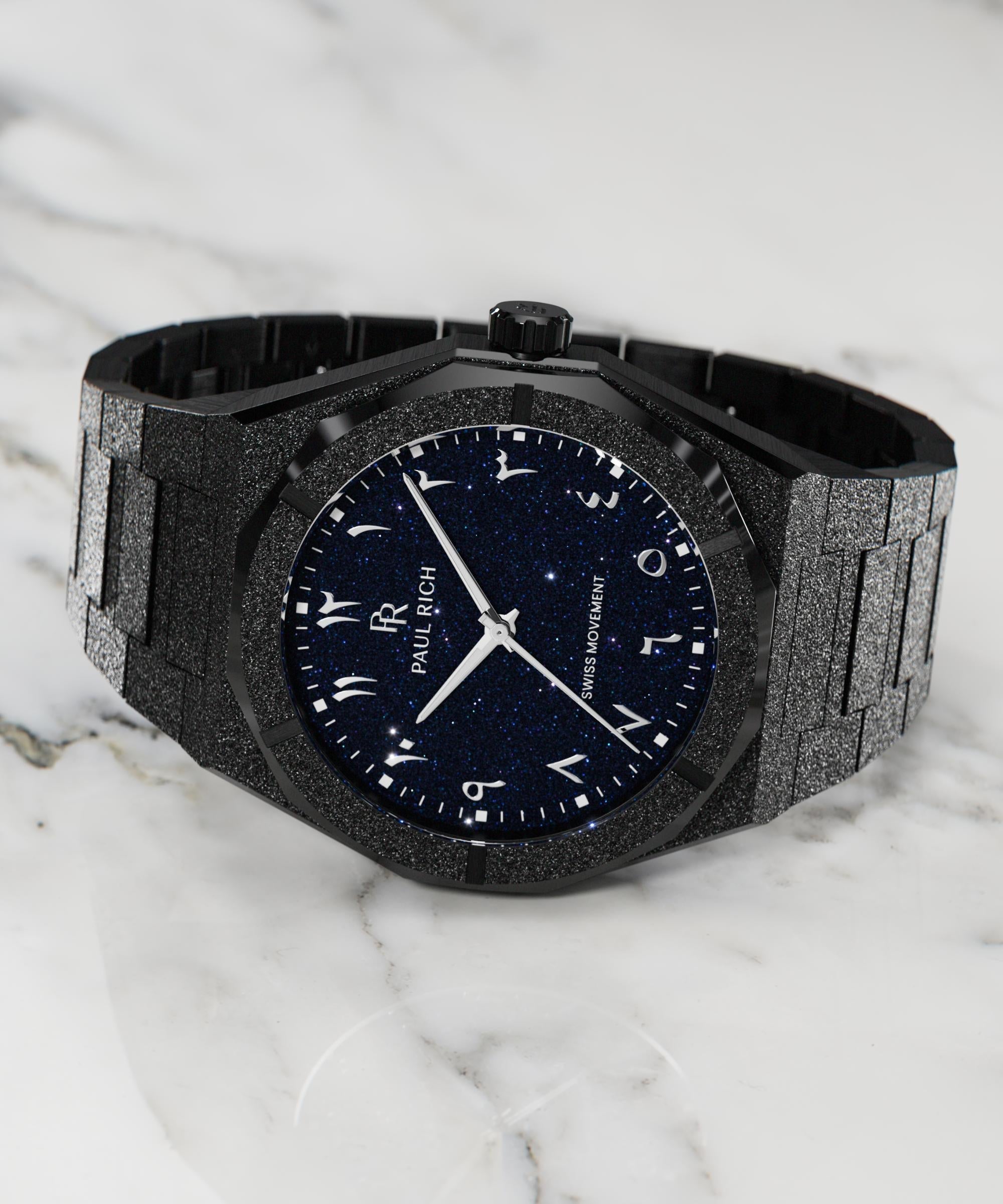 Frosted black watch with blue aventurine dial and Arabic numerals, displayed on a white marble surface.