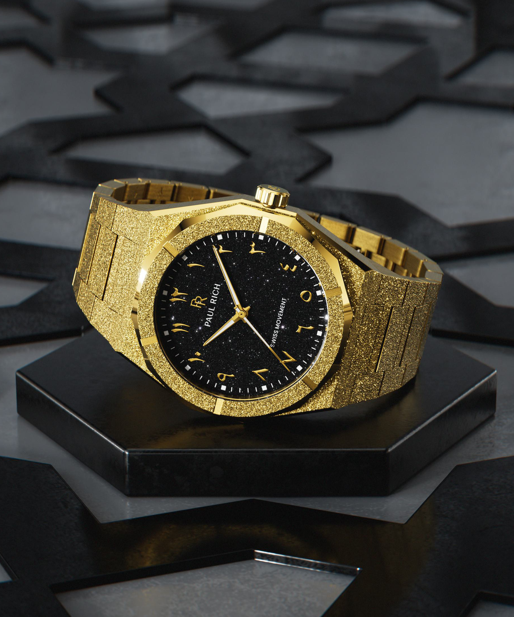 Paul Rich gold frosted watch with black aventurine dial and gold Eastern Arabic numerals, displayed on geometric black base.