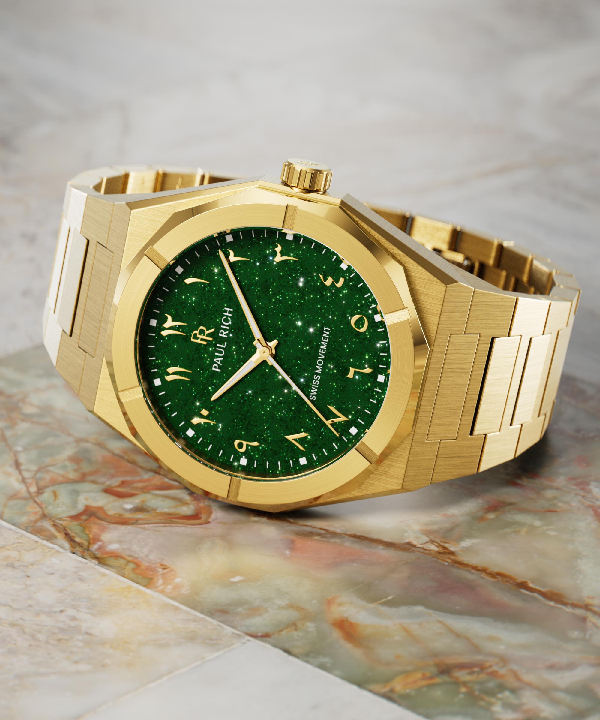 Paul Rich watch with brushed gold case and sparkling green dial with Arabic numerals, displayed on a polished marble surface.
