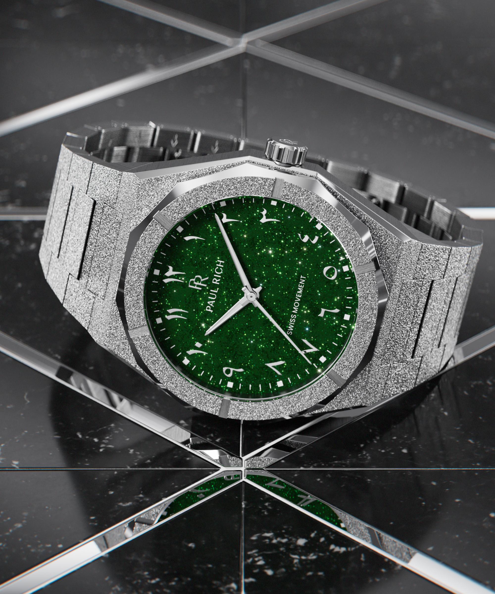 Paul Rich watch with frosted silver case and green aventurine dial with Arabic numerals, displayed on a reflective black tiled surface.