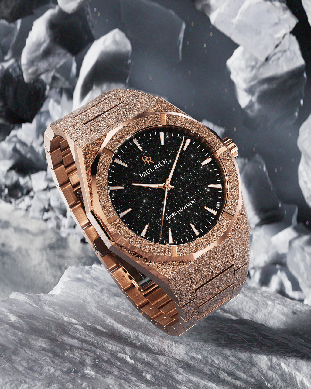 Rose gold Paul Rich watch with fully frosted case and bracelet, black aventurine dial, rose gold markers and hands, and labeled “Swiss Movement,” displayed on a rugged icy surface with floating asteroid-like rocks in the background.