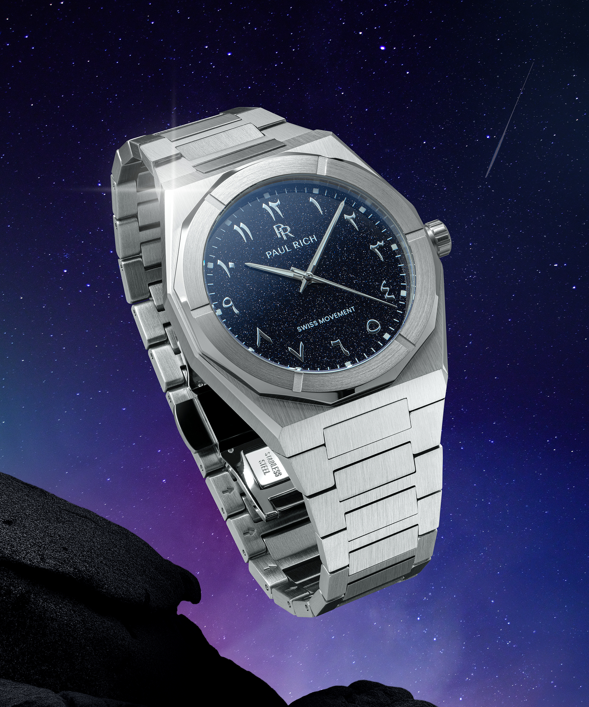 Paul Rich watch with brushed silver case and blue aventurine dial with Arabic numerals, shown against a starry night sky with shooting star.