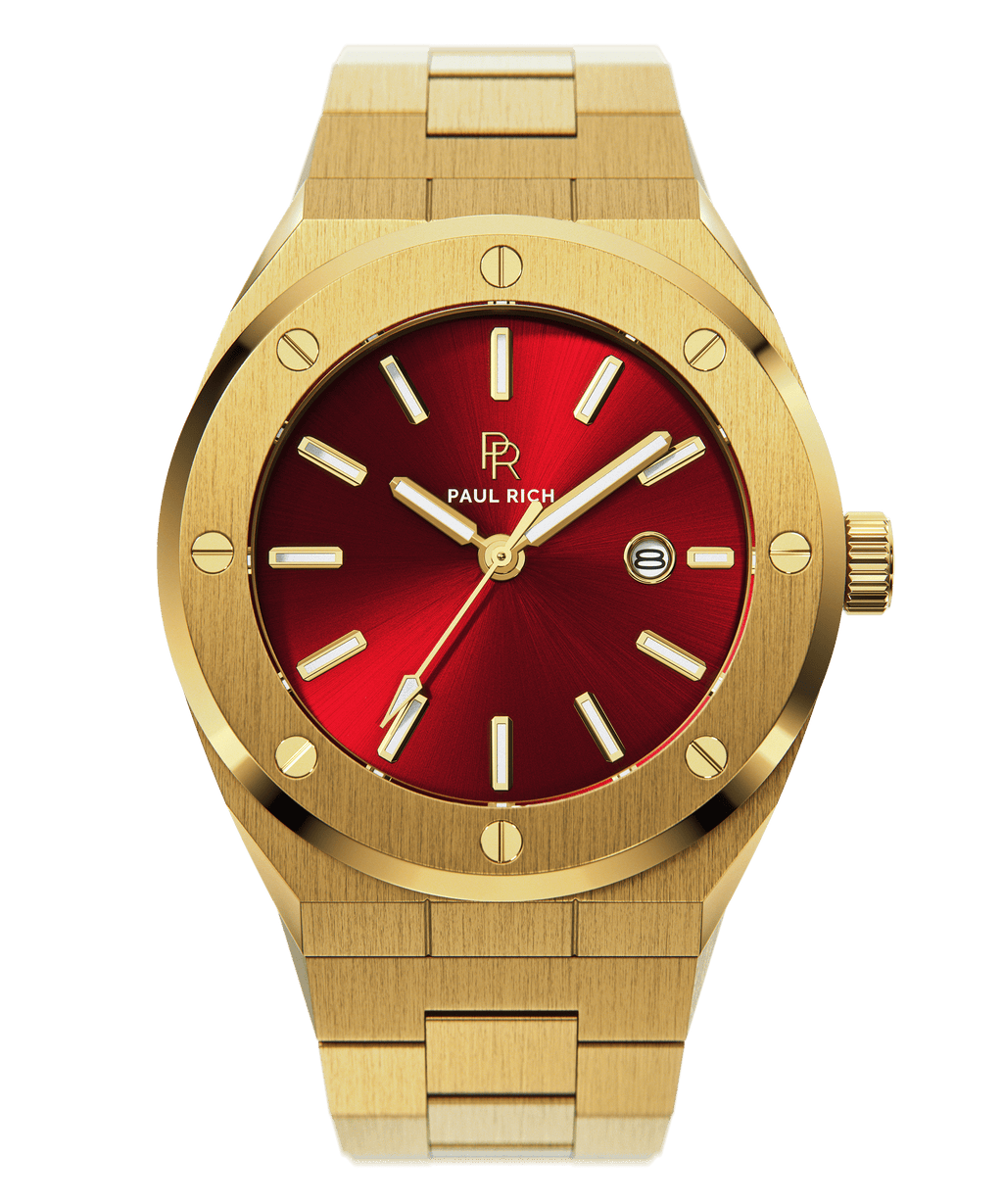 Front view of Paul Rich brushed gold watch with vibrant red sunray dial, gold markers, and date window, on transparent background.