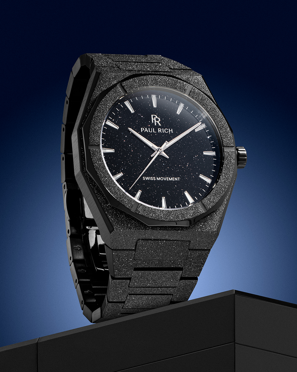 Paul Rich watch with frosted black case and black aventurine dial, displayed vertically against a blue gradient background on a black pedestal.