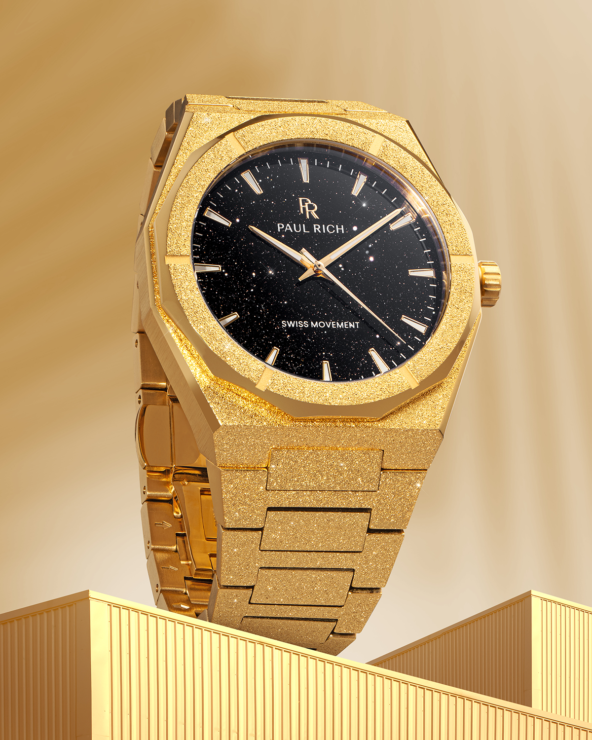 Gold Paul Rich watch with frosted case and black aventurine dial, displayed upright on a golden architectural surface with soft lighting.