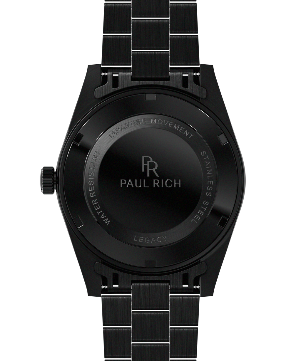 Back view of a black Paul Rich watch engraved with “Paul Rich,” “Japanese Movement,” “Stainless Steel,” “Water Resistant,” and “Legacy,” shown with a black link bracelet.