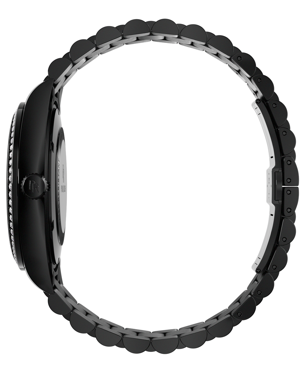 Side view of a black Paul Rich watch with diamond-set bezel, engraved crown, and fully closed black link bracelet, displayed in a circular position.